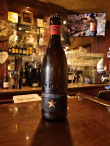 Spanish Wheat Beer Inedit Bottle featured on the bartop at Bog House Pub with glassware and bottles behind the counter